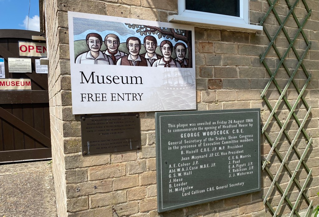 Photo of plaque and museum entry sign.