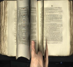 Distorted image of a page from a book with a hand. Intended to show page being turned at speed.